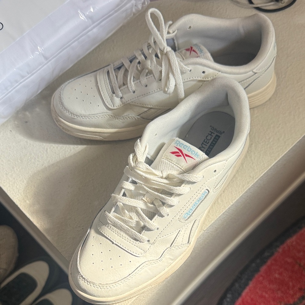 Reebok women’s Off-White Leather Sneakers with Pink Logo Accent